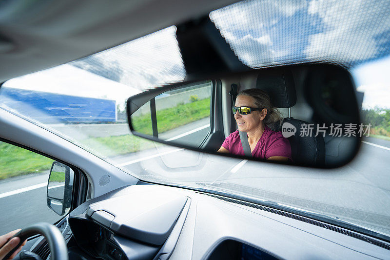 一个女人在高速公路上开车，车辆内景