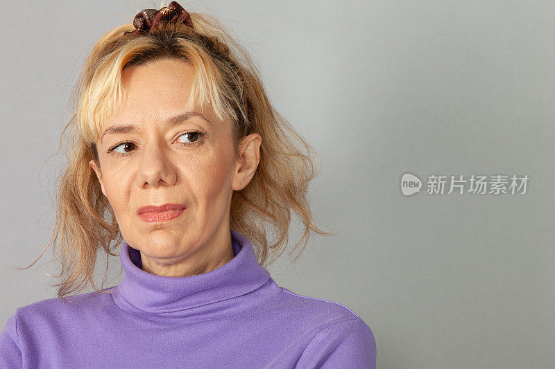 近距离工作室肖像44岁金发女人在紫色毛衣