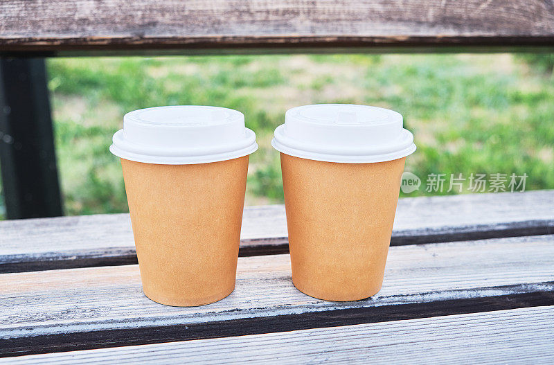 两杯咖啡带走在公园的木凳上
