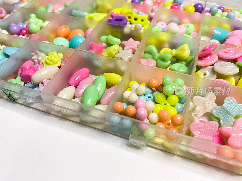 一盒彩色的珠子，制作塑料手镯或女孩饰品的工具。自己动手的概念