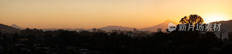 黎明时分的城市以火山为背景