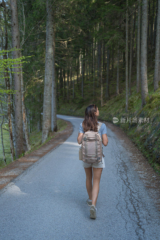 年轻女子走在林间小路上