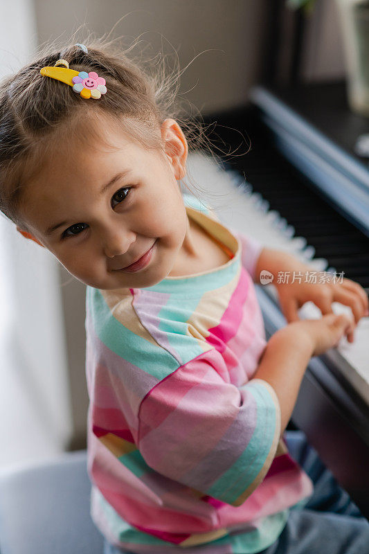 美丽的亚洲小女孩的肖像弹钢琴。