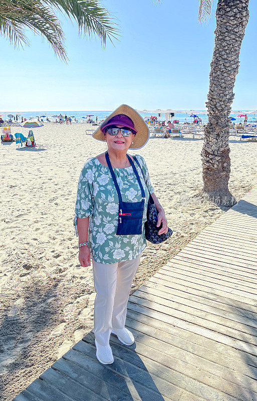 迷人的西班牙高级妇女在海滩