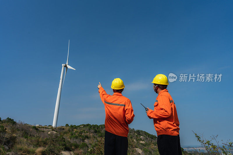 电力工程师使用平板记录风电场运行情况