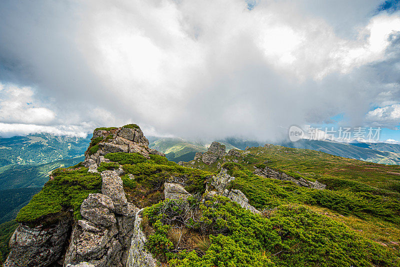 在一个阳光明媚的夏日里，有美丽的山峦和岩石景观。