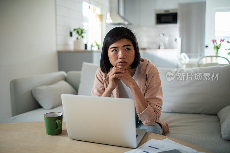 年轻女子在家里清点账单