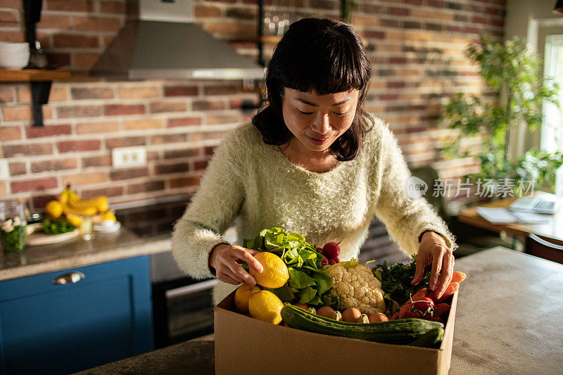 年轻的日本妇女在厨房里准备水果和蔬菜