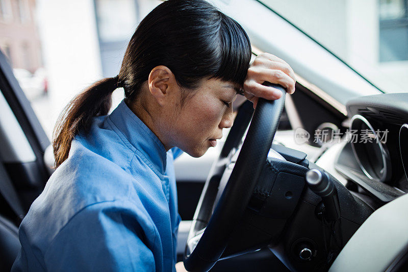 年轻的日本医护人员在车里感到疲惫和压力