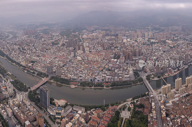 多云天，有河流的城市中人口密集的建筑物鸟瞰图