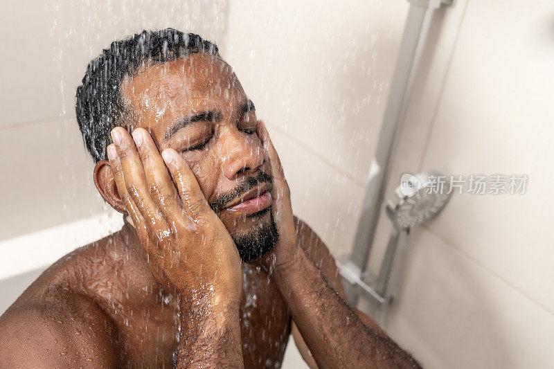 男子在淋浴时洗脸
