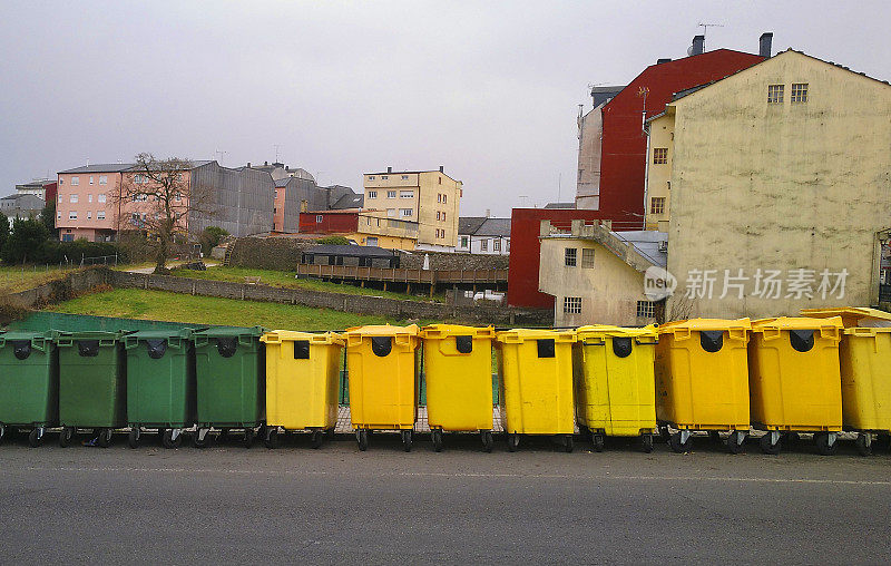 人行道旁的一排五颜六色的垃圾桶，用于回收。