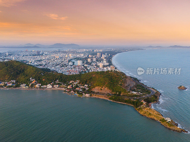 从上面俯瞰云头海岸全景，海浪、海岸线、街道、椰子树、越南Nho山后面的基督国王雕像