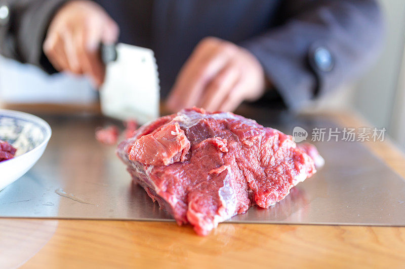 一位老人在餐厅切牛肉