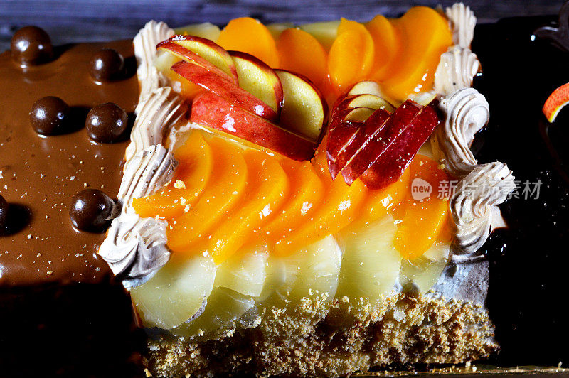 生日蛋糕三种不同的海绵奶油蛋糕庆祝，榛子巧克力涂抹，黑巧克力，焦糖，打发香草奶油，菠萝片，苹果，桃子和坚果