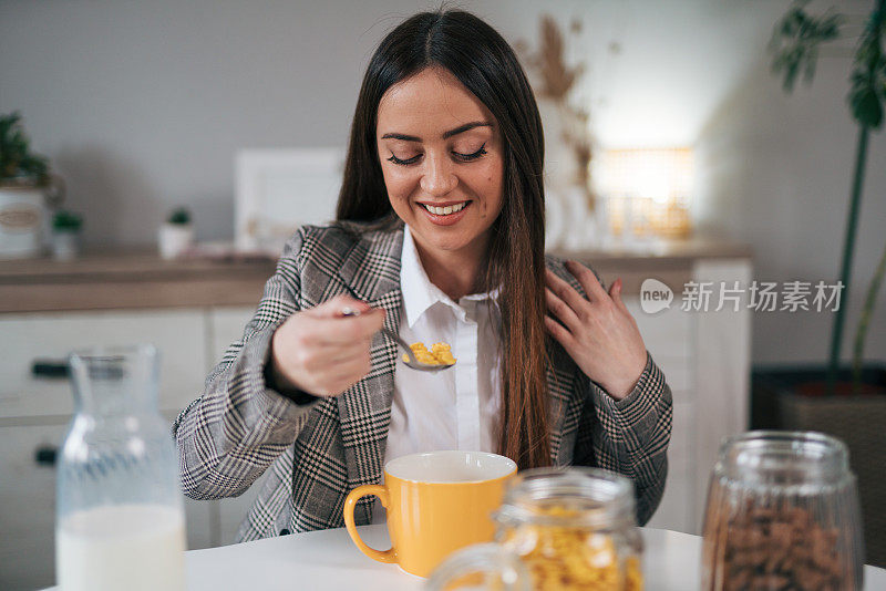 商务女性享用玉米片加牛奶，享用健康早餐