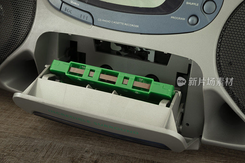 老式的绿色磁性磁带，过时的便携式收音机盒式录音机中的盒式磁带，90年代用于听音乐的复古音频设备。盒式磁带听音乐的复兴。