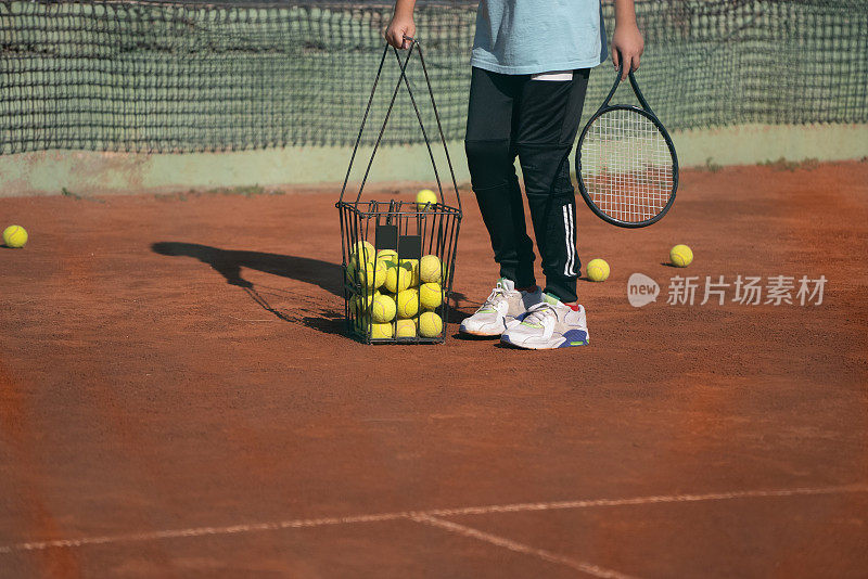 年轻的网球运动员聚集成篮网球。年轻的网球运动员在红土场上聚集成篮网球。