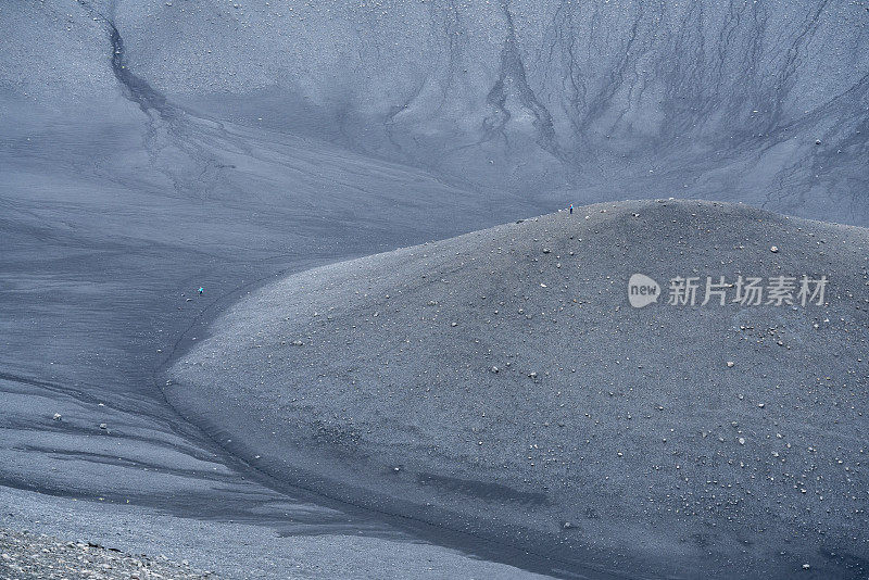 游客，两名女子在冰岛北部的赫弗哈尔火山口中部的顶部徒步旅行。