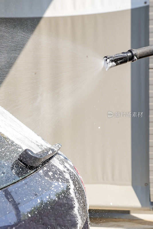 洗车。在压力下用活性泡沫清洗汽车的过程。自助手动洗车。汽车护理的概念