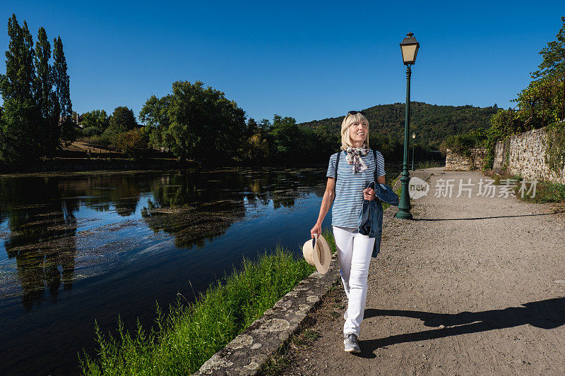 一个女人在法国阿根达的河边散步