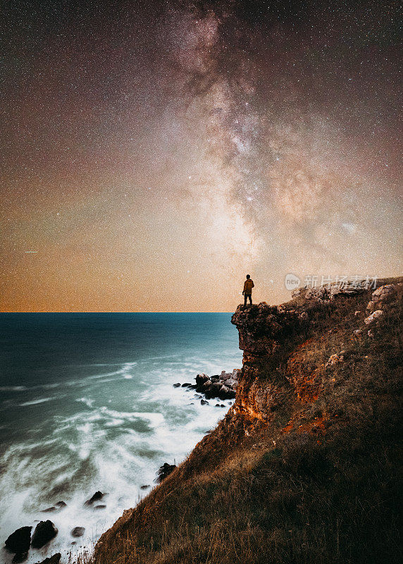 一个人站在海边的银河下