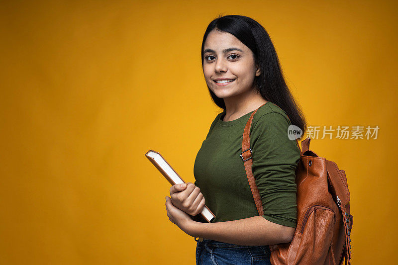 年轻的印度女人在黄色拷贝空间背景库存照片