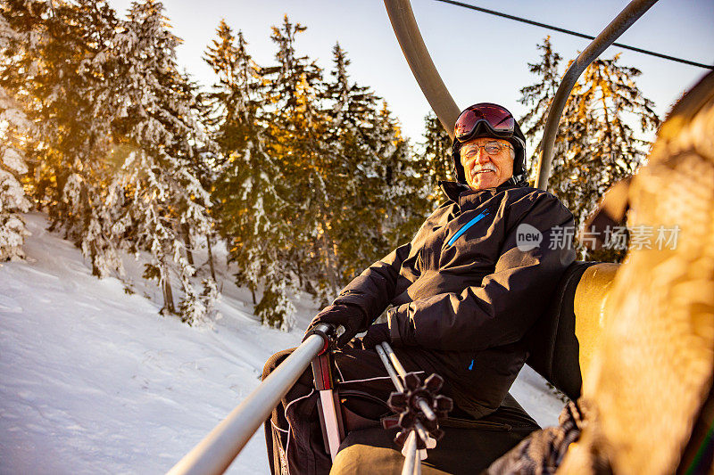 高级男性滑雪教练与不知名的女性客户乘坐缆车