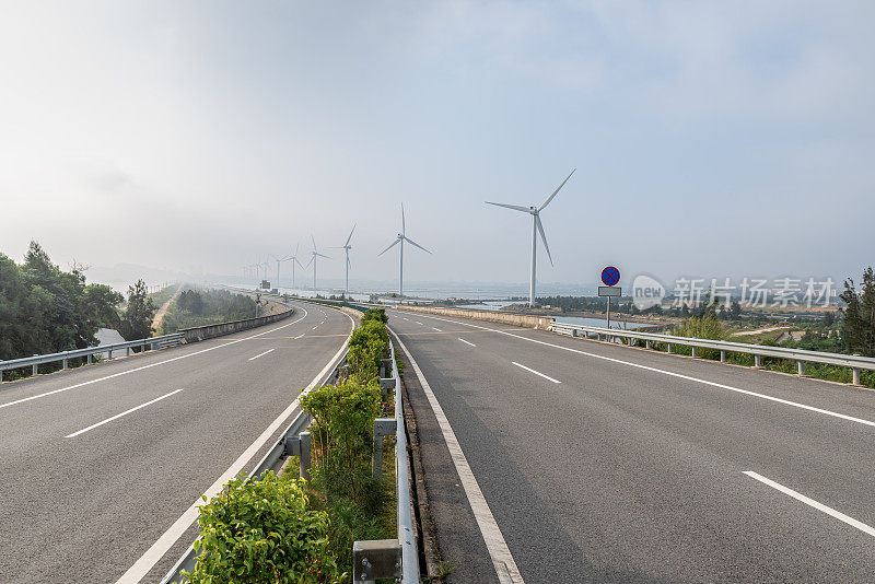 空旷的高速公路和整洁的风力涡轮机