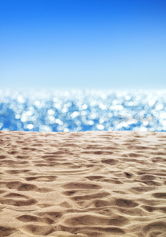 热带空旷的沙滩，阳光明媚的蓝天上有闪闪发光的海景