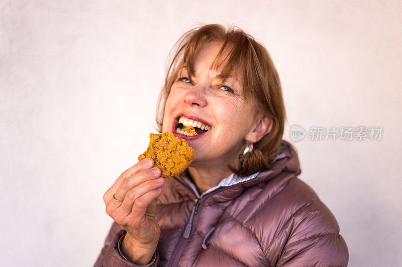 快乐的老年妇女享受饼干，复制空间