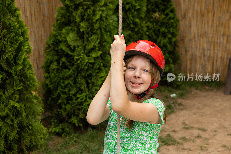 年轻的白人女孩戴着安全帽荡秋千