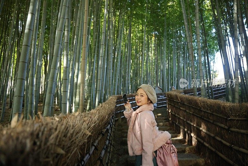 年轻女子走在竹林之间