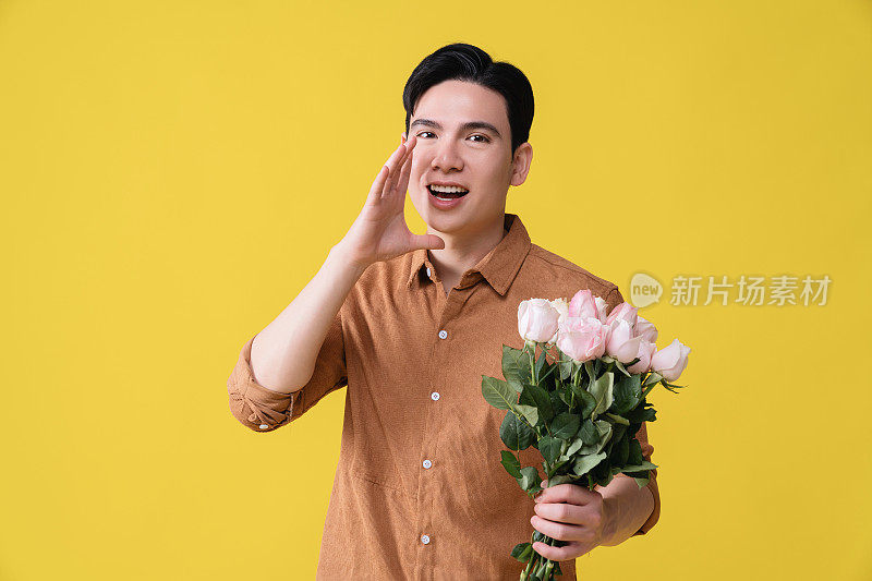 年轻的亚洲男子拿着花作为背景
