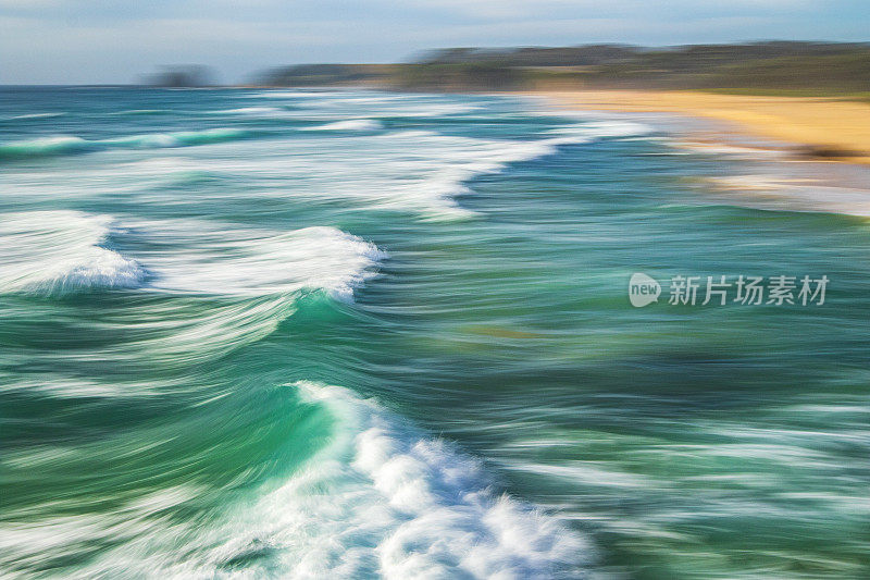 长时间曝光平滑的海浪翻滚到岩石海滩