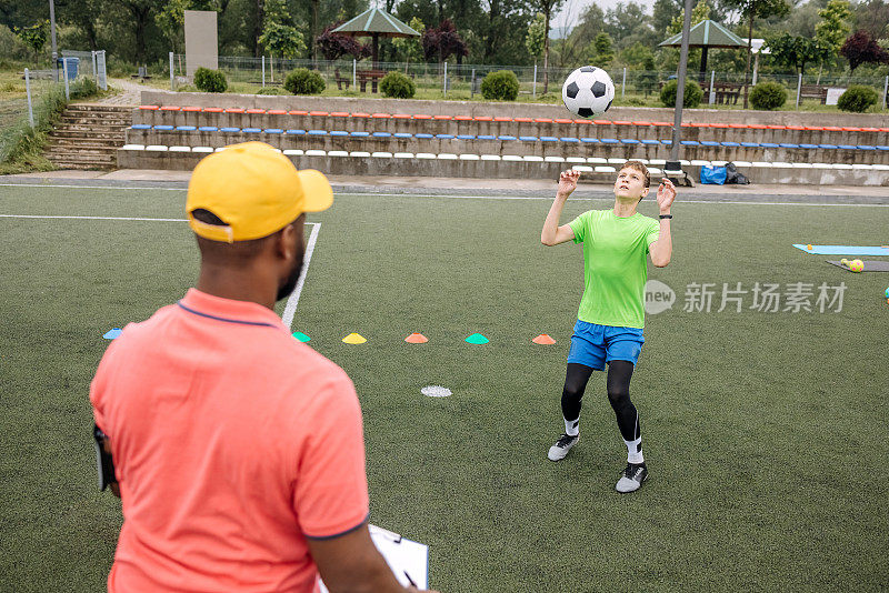 男孩正在接受黑人教练的个人足球训练