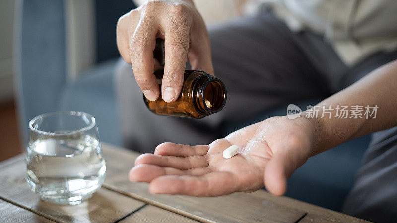 一个成年人把药瓶里的药倒在手掌里