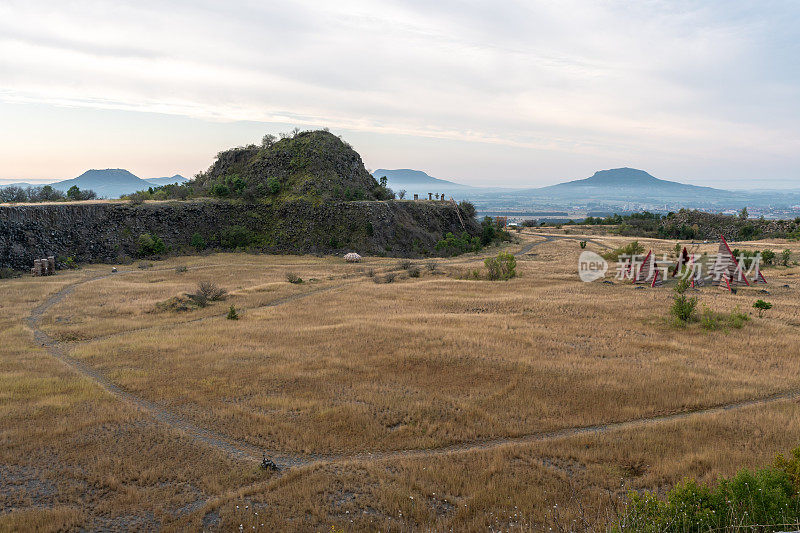 废弃的玄武岩采石场，背景是山脉