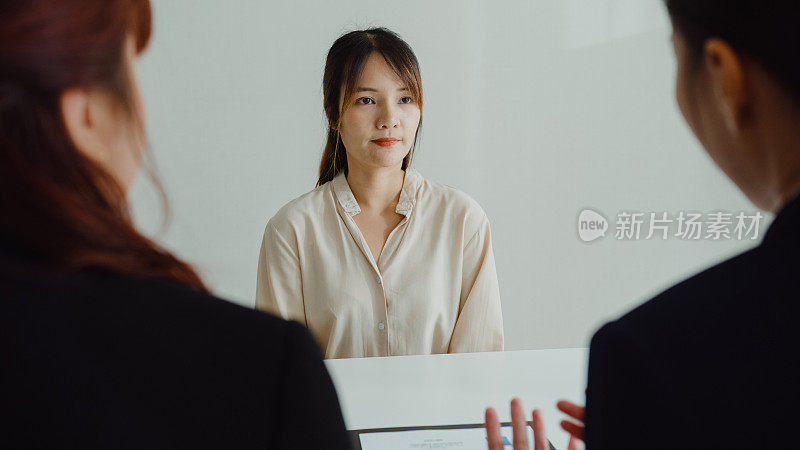 年轻的亚洲女性通过面试，坐在办公室的人力资源经理面前。人力资源，招聘机构。