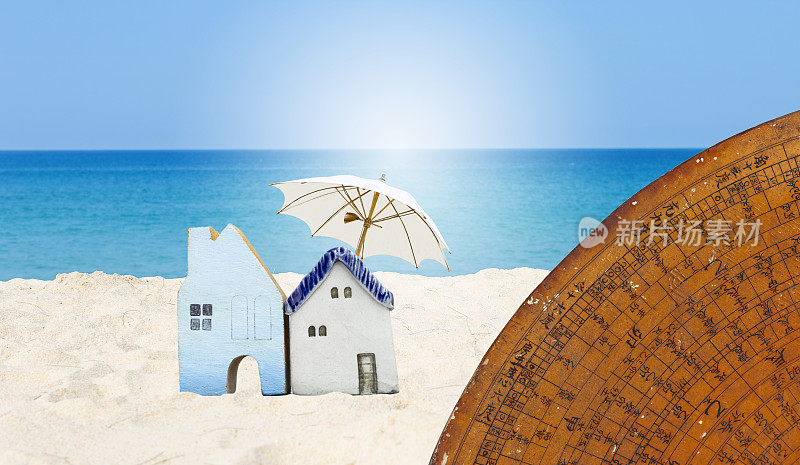 热带海滩上的迷你木屋，有古老的中国风水罗盘盘和沙滩伞