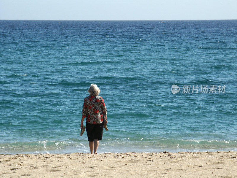 老女人在海滩上沉思