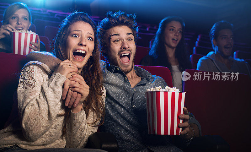 一对年轻夫妇在电影院看恐怖电影