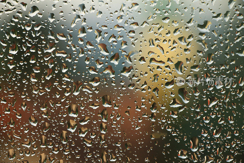 雨点落在窗户上，房子和教堂是背景