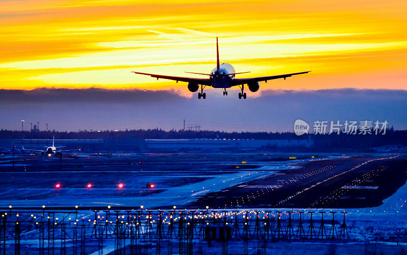 飞机在日落时降落在机场跑道上