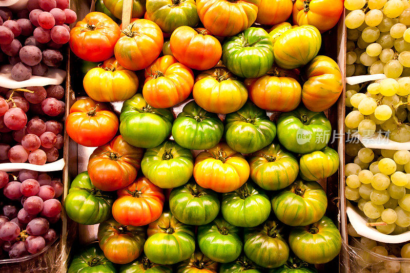在农贸市场，蔬菜和水果摊上的西红柿