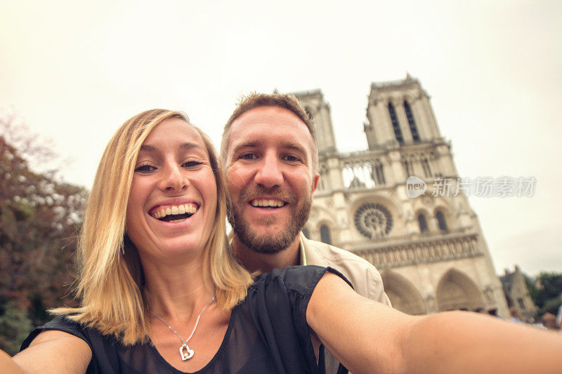 一对年轻夫妇与巴黎圣母院自拍，法国