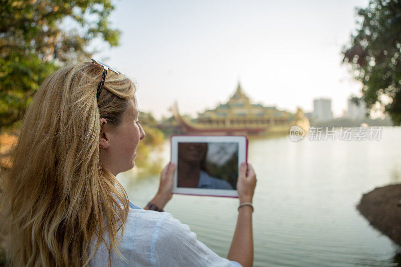 缅甸游客用数码平板电脑拍照
