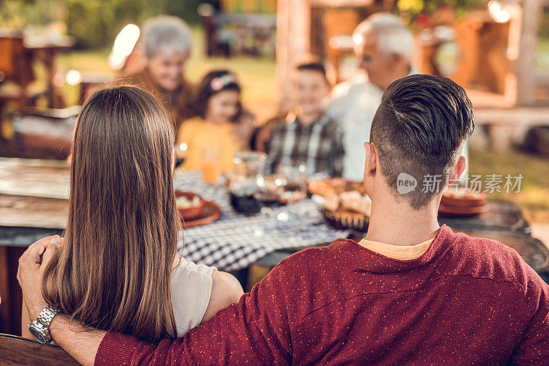 夫妇与家人在餐厅共进午餐的后视图。