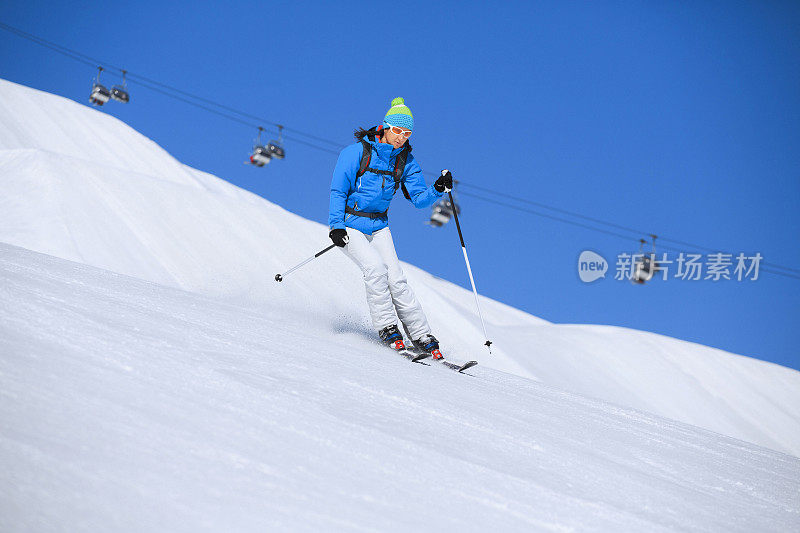 冬季运动女子滑雪者在阳光明媚的滑雪胜地滑雪