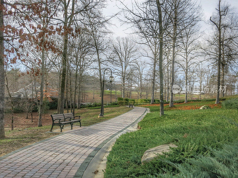 景观蜿蜒曲折的砖路步行小径，长凳